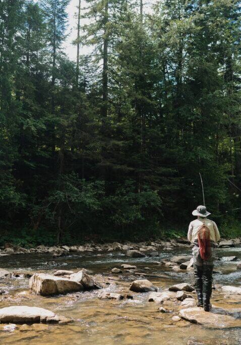 Fisherman,Casts,His,Line,Into,A,Clear,River,Flowing,Through
